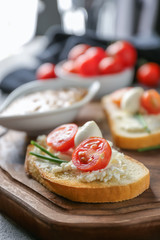 Delicious sandwich with cherry tomato and mozzarella on wooden board, closeup