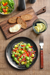 Plate with yummy brussel sprouts salad on table