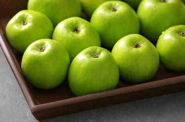 Tray with fresh green apples on table, closeup