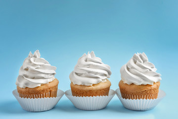 Tasty cupcakes on color background