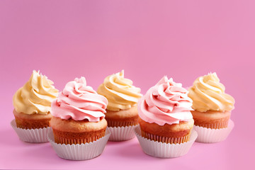 Tasty cupcakes on color background