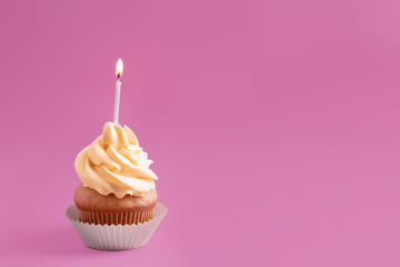 Tasty cupcake with candle on color background