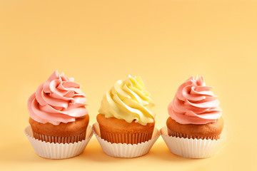 Tasty cupcakes on color background