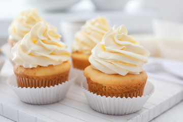 Tasty cupcakes on wooden board
