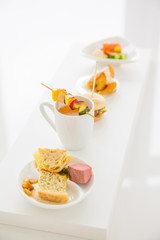 Sortiment of different appetizers ( salmon, soup, vegetable skewer,...)