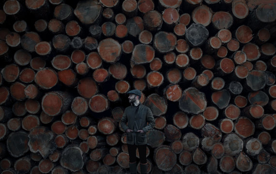 Young man in front of  lumber stockpile