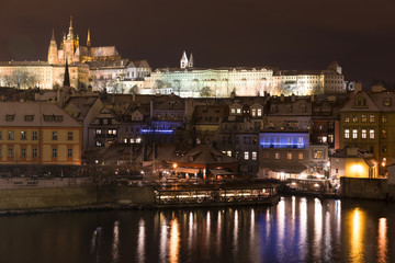 Fototapeta na wymiar Night colorful snowy Christmas Prague Lesser Town with gothic Castle from Charles Bridge, Czech republic