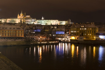 Obraz na płótnie Canvas Night colorful snowy Christmas Prague Lesser Town with gothic Castle from Charles Bridge, Czech republic