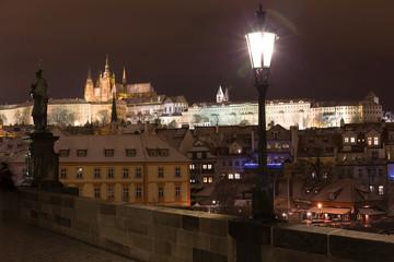 Fototapeta na wymiar Night colorful snowy Christmas Prague Lesser Town with gothic Castle from Charles Bridge, Czech republic