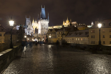 Night colorful snowy Christmas Prague Lesser Town with gothic Castle from Charles Bridge, Czech republic