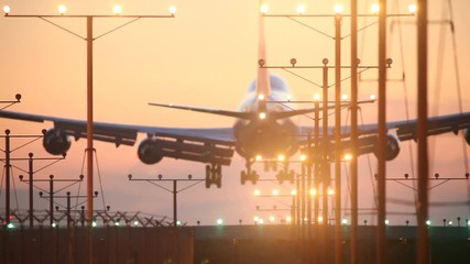 Jumbo jet airplane plane landing in airport at sunset
