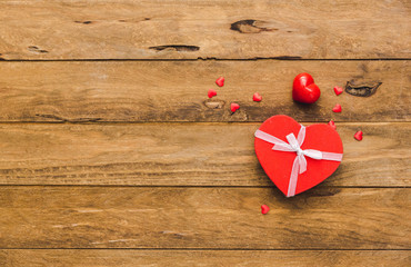 Valentines day background. Gift tied with ribbon and red heart on wooden background. presents for valentine day, birthday, mother's day.