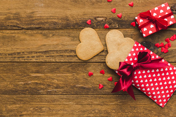 Heart cookies and gift boxes over wooden background. Top view. Copy space. Background for holidays: Birthday, Valentines day, Christmas, New Year