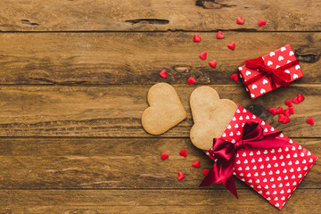Heart cookies and gift boxes over wooden background. Top view. Copy space. Background for holidays: Birthday, Valentines day, Christmas, New Year