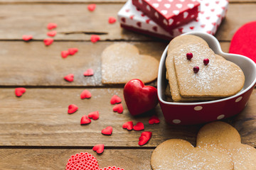 Heart shaped cookies with gifts over wooden background. Valentine day - homemade festive decorated pastry biscuits cookies