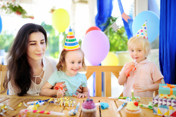 Little child and their mother celebrate birthday party with colorful decoration and cakes with colorful decoration and cake