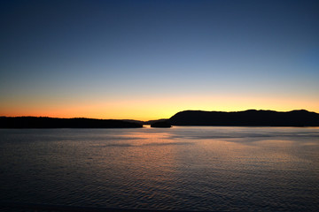Landscape view at sun set time of the many island of strait of Georgia between Vancouver and Vancouver island from a ferry going to VIctoria, Bc