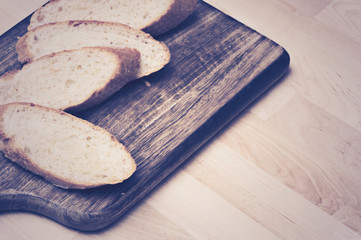 Sliced baguette bread on wooden plate