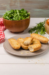 Vegetarian toasts with cream cheese, tomatoes, arugula, rosemary and black pepper on rustic wooden table
