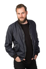 Fototapeta premium Handsome bearded man standing against a white background wearing a black tshirt and blue jacket in jeans. Looking at camera.