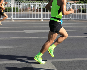Fototapeta premium marathon runner legs running on city road
