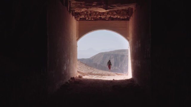 Woman on the end of a tunnel exploring the site. 4k