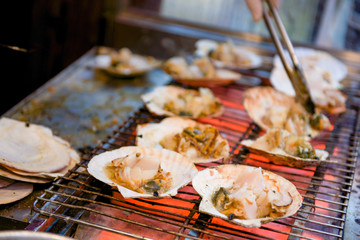 Grilled scallop with the seashell on stove in Kuromon Ichiba Market