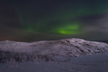 Fototapeta na wymiar Northern lights, aurora over hills and tundra in the winter.