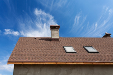 New roof with skylight, asphalt roofing (shingles) and chimney. Roof with mansard windows .