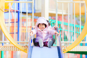 公園の滑り台で遊ぶかわいい子供