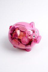 Naklejka premium Coins in the red piggy bank isolated on white. Saving and investment conceptual.