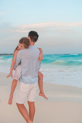 Adorable girl and young father at tropical beach. Family in the evening on the beach