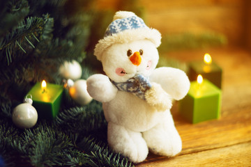 Knitted snowman on a branch of a Christmas tree. knitted Chrismas toys on green fir branches