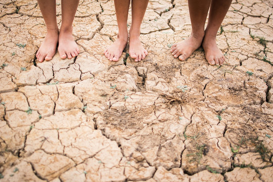Feet people on cracked dry ground .concept hope and drought