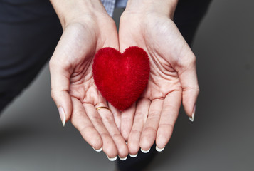 Red sweet heart in woman's hands