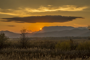 the setting sun above the hills, the far east