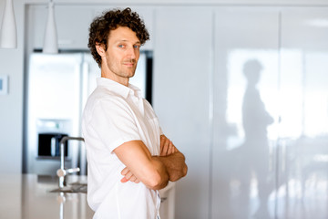 Portrait of a smart young man standing in kitchen