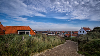 Fototapeta na wymiar Pathway through the dunes into the small town from the beach in Vlissingen 