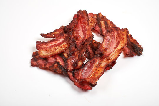 Three cooked, crispy fried bacon isolated on a white background.