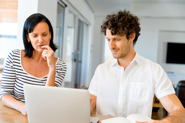 Happy modern couple working on laptop at home