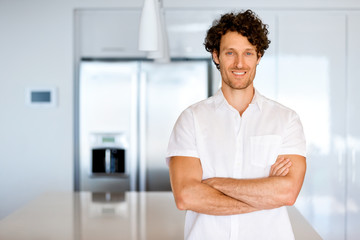 Portrait of a smart young man standing in kitchen