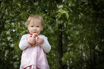 Portrait of a small girl in the park full of apple blossom trees