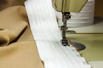 sewing curtain tape with a sewing machine, close-up