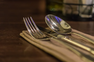 Served fork, spoon and knife on table.