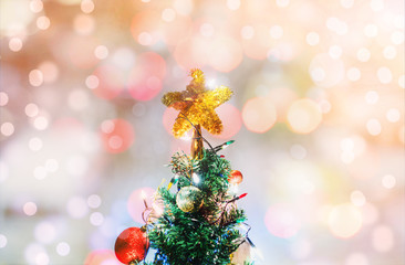 Fototapeta na wymiar Christmas star on Christmas tree, soft Bokeh lights background