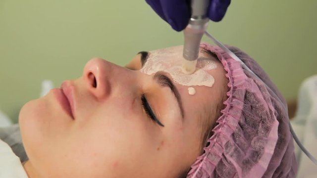 The young woman's face during the procedure closeup. Innovative cosmetic procedure. Medical procedure rejuvenation.