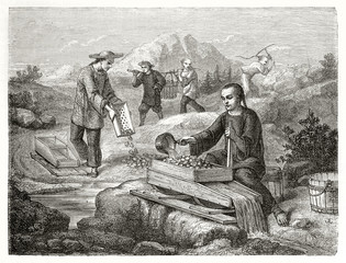 Ancient chinese miners sifting and washing gold-bearing sand, outdoor in California. Created by Chassevent after previous engraving by unknown author published on Le Tour du Monde Paris 1862