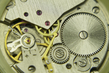 Old mechanical watch mechanism close up, clock inside gears background, vintage technology.