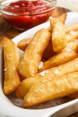 french fries with salt and ketchup in a glass bowl