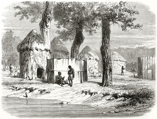 Ancient native africans in their made by huts village close to a river. Nouen African village along the White Nile. Created by Girardet after Bolognesi published on Le Tour du Monde Paris 1862